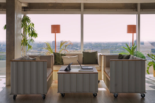 Sunny modern office lounge with city view and mobile furniture