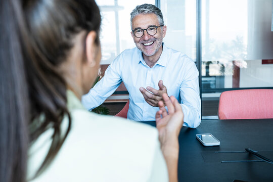 A manager discusses business with a woman at the office