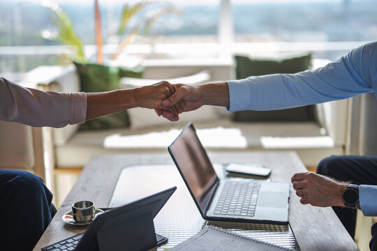 Man and woman share a handshake over a contract at the office