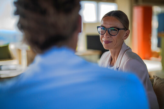 Businesswoman smiles at businessman during office consultation