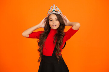 Confident teen girl in crown at birthday party. Party celebration. Girlish princess crown. Happy teen girl in princess crown. Party princess. Happy birthday. Birthday girl isolated on orange. © be free