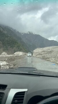 Snow-cleared dirt road framed by high ice walls along Babusar Pass in the Kaghan Valley.