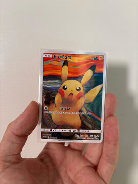 Hamburg, Germany - 09052026: male hand holding fake Pikachu Munch Exhibition PROMO card, fan made paper trading card.