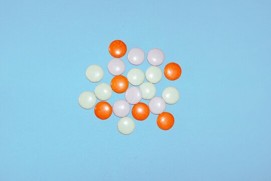 Colorful chocolate candy drops clustered on a blue background