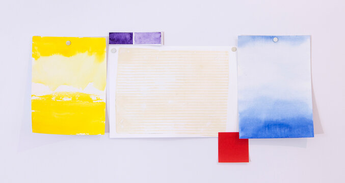 Colorful watercolor paper swatches pinned on a white mood board