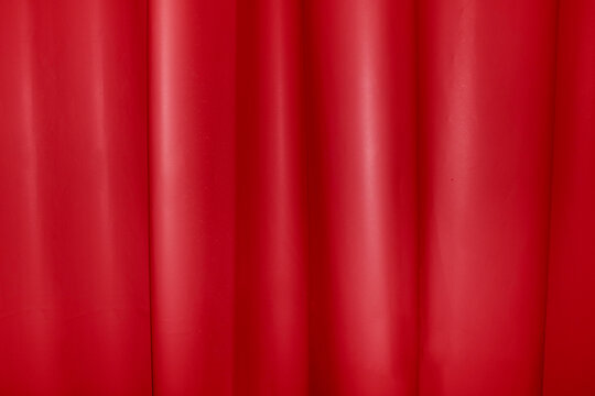 A red theater curtain creates a textured fabric background
