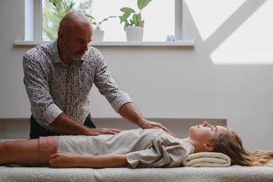 Osteopath performs manual therapy on woman in clinic