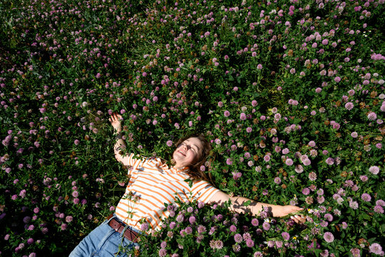 Woman enjoys a summer field of pink clover
