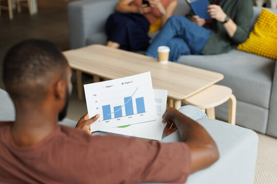 Businessman analyzing financial chart in a casual office workspace