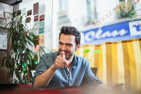 France, Paris, portrait of smiling man sitting in a cafe