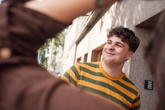 Happy man talks with a woman outdoors on the city street