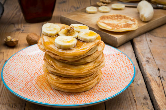 Pancakes with walnut, maple syrup and banana on plate