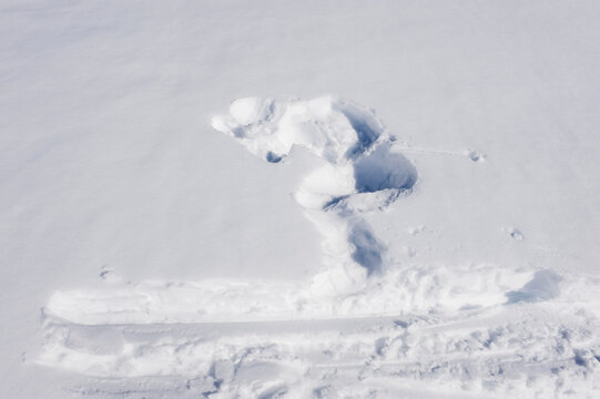 An imprint of a fallen skier marks the white snow in Italy
