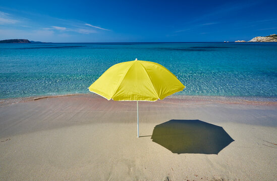 Italy, Sardinia, yellow sunshade on the beach at Rena Majori
