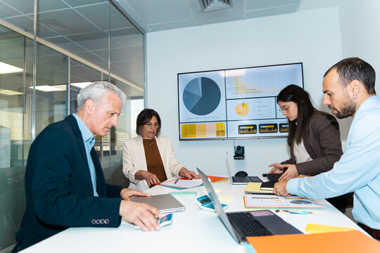 A business team prepares documents inside a modern conference room