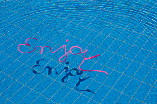 Word enjoy in water of a swimming pool