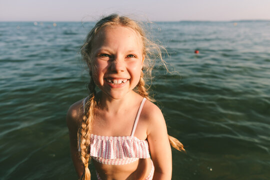 A smiling girl enjoys the sea water during her summer vacation