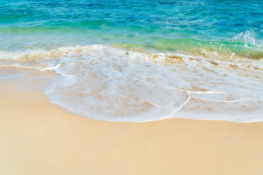 Gentle turquoise wave washes over the sandy beach in Fuerteventura
