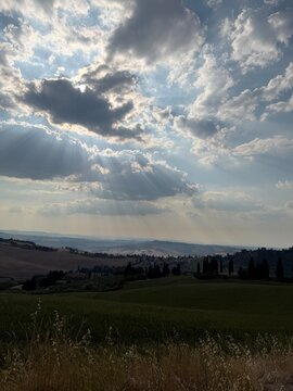 Dramatic sun rays breaking through clouds over countryside