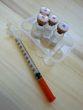 Reta, retatrutide peptide in a vial and bacteriostatic water on a wooden background