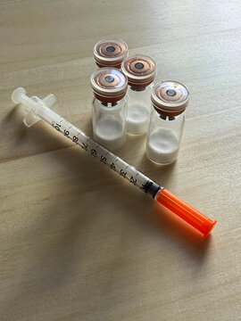 Reta, retatrutide peptide in a vial and bacteriostatic water on a wooden background
