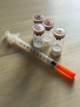 Reta, retatrutide peptide in a vial and bacteriostatic water on a wooden background