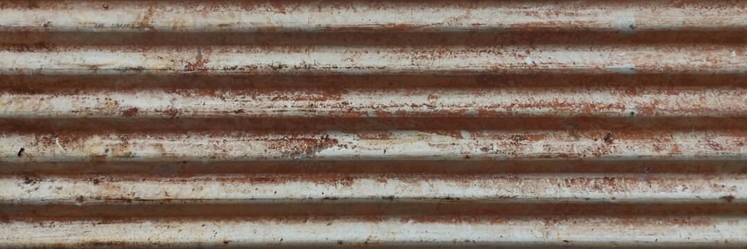 Corrugated metal surface showing rusty, weathered texture and horizontal lines