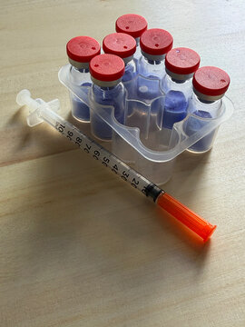 GHK-Cu, copper tripeptide in a vial and bacteriostatic water on a wooden background.