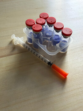 GHK-Cu, copper tripeptide in a vial and bacteriostatic water on a wooden background.