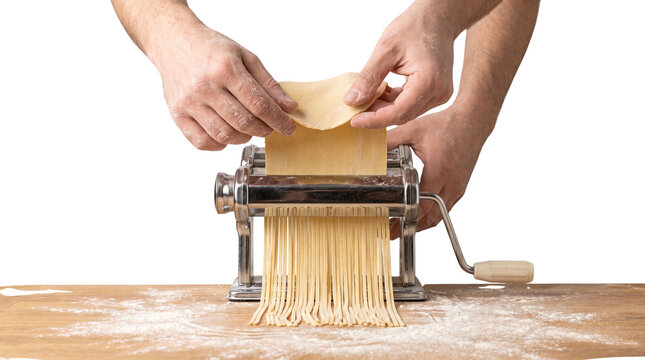 Professional pasta machine cutting fresh dough into noodles. Chef hands making homemade pasta. Traditional Italian cooking process. isolated PNG with Transparent Background