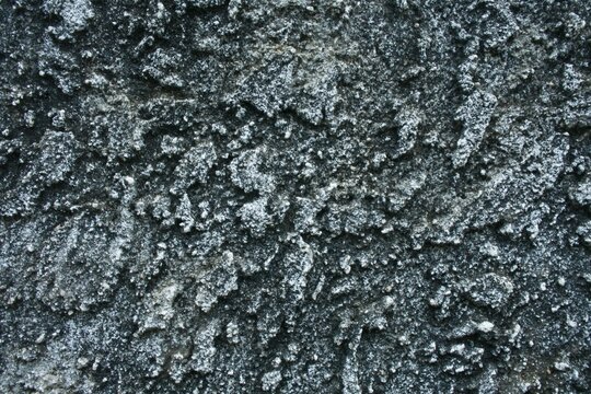 Rough knockdown stucco wall texture, grey concrete background with flattened splatter pattern