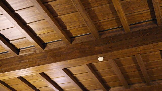 Low angle view of renovated ceiling made of wooden planks painted with brown colour, process of restoration of antique houses, home improvement concept