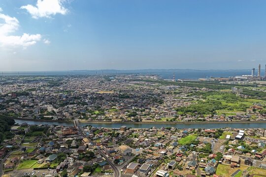Aerial drone photo of urban residential area with river and solar panels in Kimitsu, Chiba, Japan