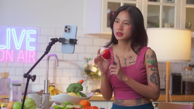 Content creator live streaming cooking show with neon "on air" sign, food vlogger gesturing while presenting fresh vegetables and fruits, healthy eating tutorial recording concept