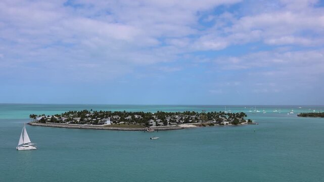 Key West Florida. Panoramic view of a sailboat sailing on clear turquoise ocean water near Sunset Key