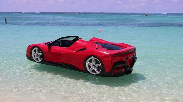 Red sports car shaped floating lounge craft in ocean water beach near George Town Grand Cayman, Cayman Islands