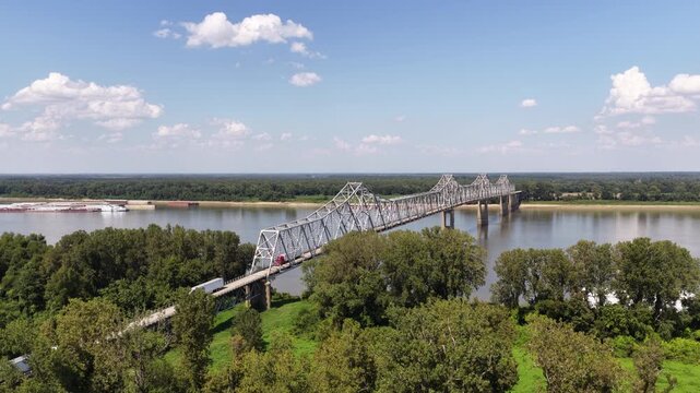 Aerial of truss bridge crossing Ohio River in Cairo Illinois at Kentucky and Missouri border with barge on water