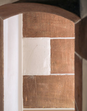 In einer alten Kapelle roter Sandstein und ihr schmaler Durchgang, Torbogen mit Licht und Schatten, stimmungsvoll