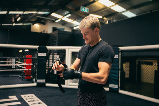 MMA fighter putting his gloves on in a ring