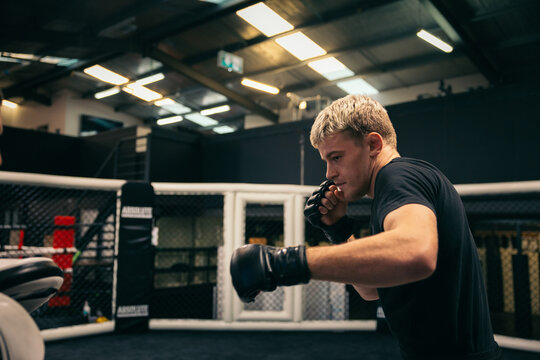 Fighter practicing punches in an MMA cage