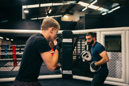 Fighter and trainer during pad session in MMA gym