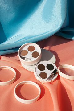 Minimalist Eyebrow Makeup Palette Flat Lay on Pastel Satin Fabric