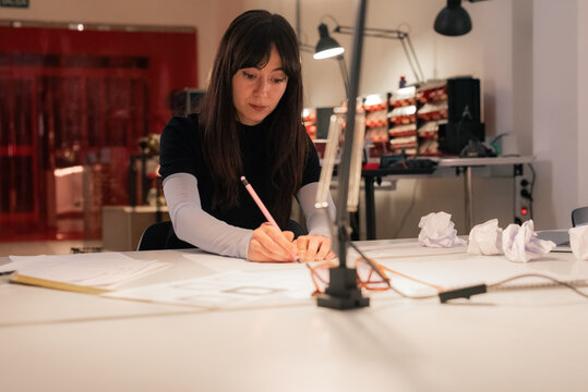 Young woman drawing sketches at creative studio office