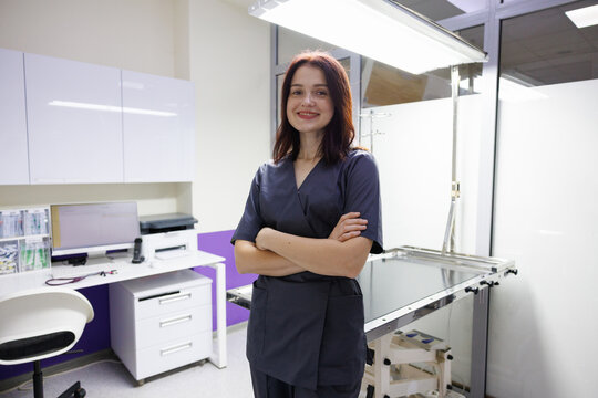 Portrait of smiling female doctor with crossed arms in clinic room