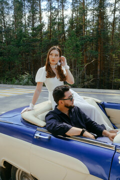 Young Couple in Vintage Convertible on a Forest Road