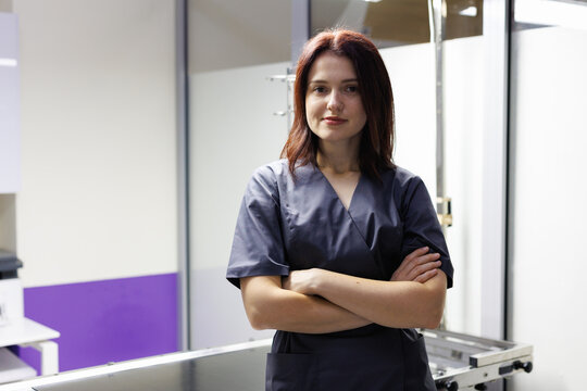Portrait of young female doctor with crossed arms looking at camera