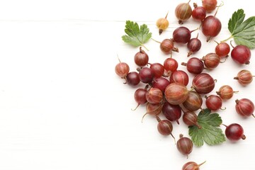 Fresh red gooseberries and green leaves on white wooden table, flat lay. Space for text © New Africa