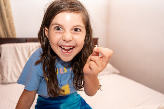 Excited Child with Lost Tooth in bedroom