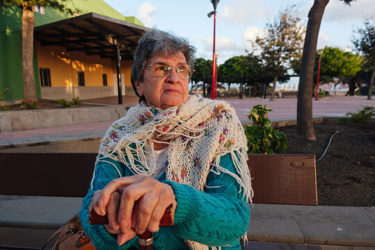 Senior woman relaxing on a park bench outdoors