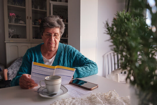 Senior woman reading bills letter at home